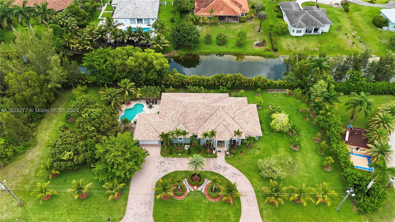 Welcome to this exceptional one-story home in Southwest Ranches, set on a spacious builder’s acre lot. This 4 bed, 4.5 bath home features soaring ceilings, updated bathrooms, porcelain and tile floors, and a functional split floor plan. The fenced backyard offers canal views with dog run, an 8ft waterfall pool with a new pump, jacuzzi & 1,100 SF covered patio with an outdoor kitchen and fruit trees. Additional features include a 2-car A/C garage, tankless water heater and A/C (2018), and a circular driveway that fits 8–10 cars. With no HOA restrictions, this property offers excellent flexibility for short or long-term rentals and is currently operating as a successful Airbnb. Ideal as an investment, vacation home, or the opportunity to redesign and create your dream home