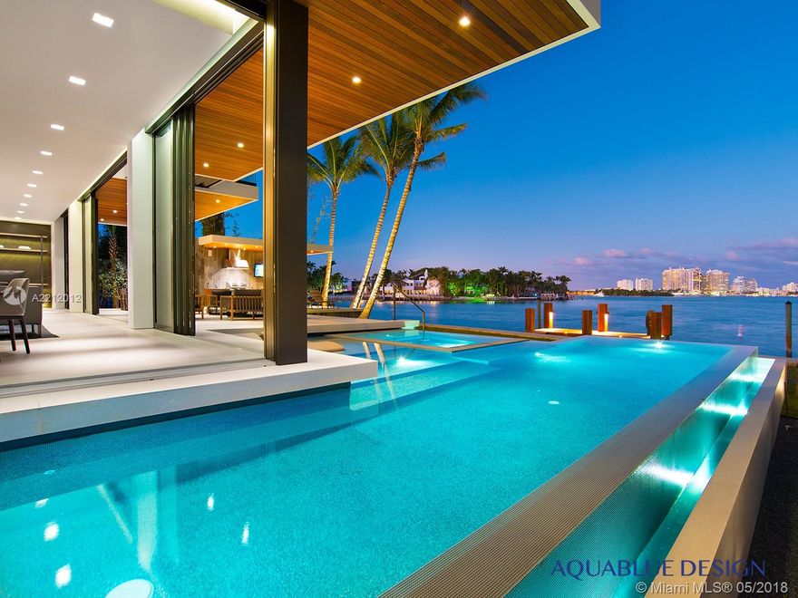 Contemporary Miami Beach luxury waterfront home.   Open plan living spaces with idyllic transitions to expansive outdoor living areas. Overlooks 110 feet of waterfront views of South Beach. Floor to ceiling rear sliding doors, infinity-edge pool and spa, custom Italian kitchen and closets, elevator to rooftop terrace, fully automated home with Crestron System.