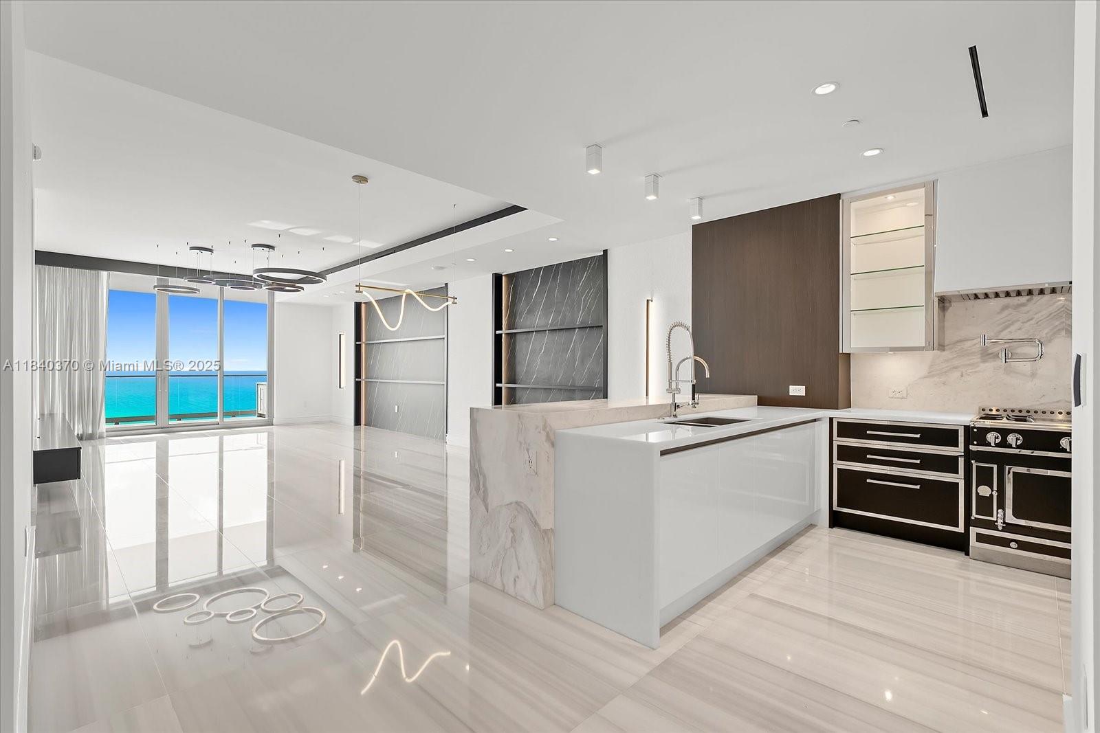 This chic, monochromatic masterpiece is perfectly accented with bold splashes of color and framed by sweeping views of the turquoise Atlantic. Spanning a spacious layout, this flow-through residence offers 4 bedrooms plus a family room, ideal for sophisticated living and entertaining.
Designed with impeccable taste, the home features genuine marble flooring, custom millwork and built-ins, and an onyx-clad primary bath with a steam shower. Molteni custom closets grace every bedroom, while the chef’s kitchen impresses with a La Cornue gas range and luxury finishes. Enjoy seamless indoor-outdoor living with two expansive terraces, a summer kitchen, and full smart home automation.
Set within Miami’s most prestigious oceanfront address, The Estates at Acqualina.
