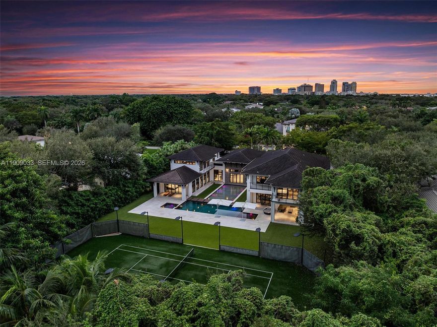 Welcome to The Sanctuary at Pinecrest, a private haven of modern elegance and timeless design. This gated estate offers approx. 11,300 SF of living space on a 1.16-acre lot with 7 bedrooms and 11 baths, including two luxurious primary suites. Soaring ceilings, walls of glass, and refined finishes define the interiors, featuring a chef’s kitchen, formal and casual living areas, gym, media room, office, and guest quarters. Outdoors, enjoy an infinity-edge pool, summer kitchen, covered terraces, private tennis court, and two fountains framing the main entrance. Complete smart-home automation, elevator, and lush tropical landscaping enhance this architectural masterpiece.