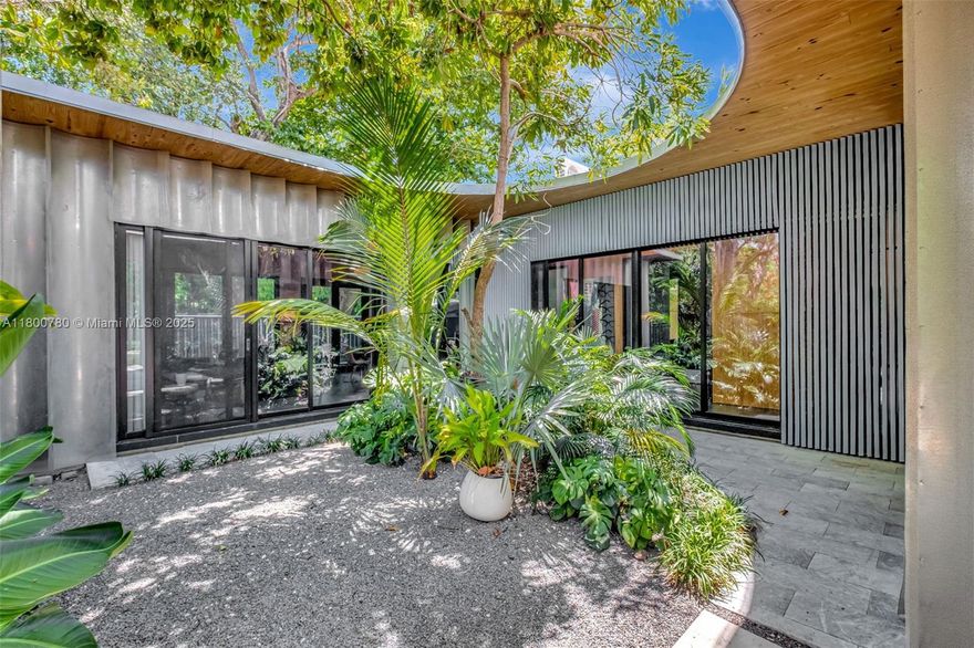 House In A Garden is a distinctive 4-bedroom, 3-bath pool home in Coconut Grove, designed by renowned local architecture firm Atelier Mey and crafted from sustainable mass timber with soaring 11'+ ceilings throughout. This thoughtfully designed single-story home pays homage to the Grove’s Bahamian roots with a full-width front porch that fosters a connection to the community. At its heart, an open-air courtyard brings natural light and lush garden views into every room. The layout wraps around the courtyard, promoting passive cross-ventilation from the south pavilion through the living spaces. Blending indoor comfort with outdoor tranquility, the home offers  timeless architectural appeal. Near top schools, parks, dining, and all the charm of Coconut Grove’s ongoing renaissance.