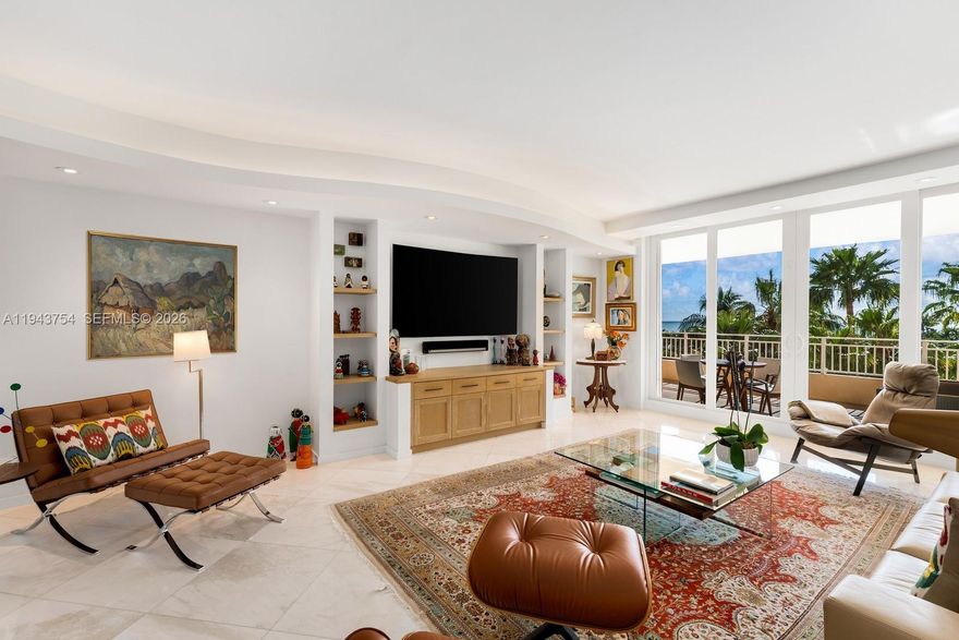 Unique opportunity to own a custom-designed and remodeled 2,605 SF residence in The Ocean Club’s most desirable beachfront building, Ocean Tower Two. Originally a three-bedroom, the residence has been reimagined as a spacious, light-filled two-bedroom with library/den and generous living and dining areas.

Architectural curves, rounded built-in shelving, and layered lighting define the home’s distinctive character. Custom millwork—harmoniously carried throughout the kitchen, library, closets, and bookshelves—adds warmth and a cohesive aesthetic. Polished marble floors, recessed and cove lighting, and refined wall surfaces create an elegant, modern interior ideal for displaying art and furnishings. The library features an electric fireplace, offering an inviting retreat.

The open kitchen integrates seamlessly with the living areas and features custom cabinetry, an island cooktop, and Thermador appliances. The primary suite offers a tranquil retreat with refined finishes and beautiful views, while the primary bath is finished in marble and glass with custom vanities and a walk-in shower. Ocean views are enjoyed from within the main living areas, as well as from two spacious terraces overlooking lush tropical gardens, resort pools, and the Atlantic.

The Ocean Club provides luxurious resort-style living: beach, pools, restaurants, fitness center with ocean views, spa, salon, playground, playrooms, 7 Har-Tru tennis courts, 3 padel courts, security and valet services.