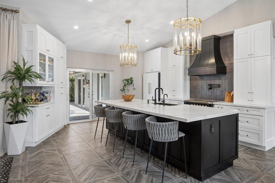 Shenandoah’s most impressive home is finally available. This 4-bedroom, 2.5-bath pool home has been upgraded with the kind of finishes you simply do not find at this price point. The kitchen alone sets this home apart. A professional ILVE Majestic induction range sits beneath a commercial hood, accompanied by a panel-covered double-stacked dishwasher, panel-covered integrated refrigerator, microwave drawer, dual-temperature wine cooler, and quartzite countertops. A crystal chandelier crowns the 10-foot-plus island, which features double-deep cabinetry along the seating side, offering storage that most kitchens cannot match. The primary suite delivers a genuine sense of retreat with a Roman soaking tub, dual vanities, glass-enclosed shower, and a generous walk-in closet. The home includes a thoughtfully designed ADA-modified bathroom, making this home as practical as it is beautiful. The newly renovated half bath impresses with elegant finishes and marble floors. A wooden wrapped skylight adds a unique accent to the family room. The screened pool and generous patio create a private setting for entertaining or simply unwinding. The climate-controlled garage with a dedicated mini-split offers flexibility well beyond the typical home. Porcelain tile flows through the common areas, ceramic tile carries into the bedrooms, and a newer AC keeps everything comfortable year-round. Homes like this rarely come to market. This home is a true sanctuary. This one is a "MUST SEE"!