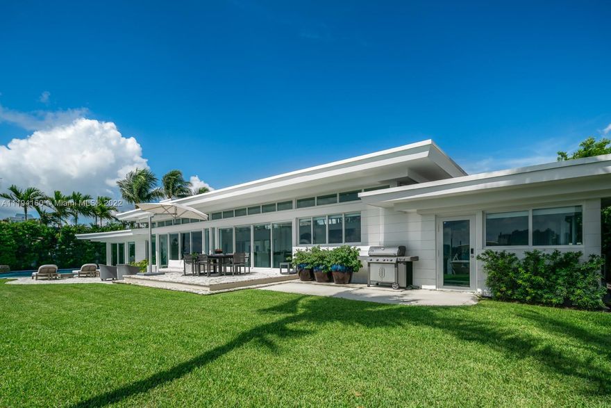 An opportunity rarely seen - a renovated MiMo style home in the jewel community of Davis Harbor. Distinctly restored in 2020 by its owner/designer, the ceilings heights, walls of glass & natural light have been fully optimized. The wide bay views from Bayshore Drive boasts 129ft of open waters with calm Eastern breezes. This property is positioned on an expansive 16,580 SF Lot with private, tropical landscaping. The home features restored Terrazzo flooring, a modern chef's kitchen with Subzero and Viking appliances including gas cooktop and grill, fully-automated Savant smart home system along with high-res camera security system throughout the property exterior. The outdoor oasis is appointed with a heated saltwater pool/spa along with a newly installed boat lift with 24k ton capacity.