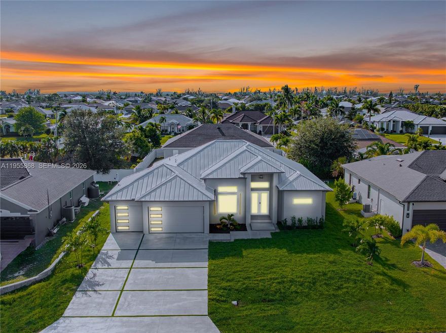 Crafted without compromise, this bespoke residence is a statement of timeless luxury and intentional design, built with excellence from its solid limestone foundation to its sleek metal roof. Every element was thoughtfully executed with precision, quality, and longevity in mind.Grand, soaring ceilings and expansive interiors set the tone, complemented by a spacious 3 car garage. A striking floating walkway creates a dramatic arrival at the front door, while the designer driveway with modern turf inserts enhances the home’s architectural presence. Surrounded by Gulf-access, million-dollar homes, the setting offers both prestige and exclusivity. Inside, generous room proportions and tall walls create a refined sense of scale. Electrical outlets were strategically placed to allow mounted televisions with no visible wiring demonstrating the home’s attention to both luxury and functionality. The primary suite is a true retreat, featuring expansive his and hers closets, a spa inspired soaking tub, and a stunning shower accented by infinity mirrors for a hotel level experience. The third bathroom is conveniently positioned at the rear of the home, perfectly designed to serve a future pool ideal for effortless indoor outdoor entertaining and elevated gatherings. Located less than five minutes from Publix, dining, fuel stations, and just moments from Cape Coral’s highly anticipated Majestic 7 Islands Project, this home offers refined living in one of the area’s most exciting locations