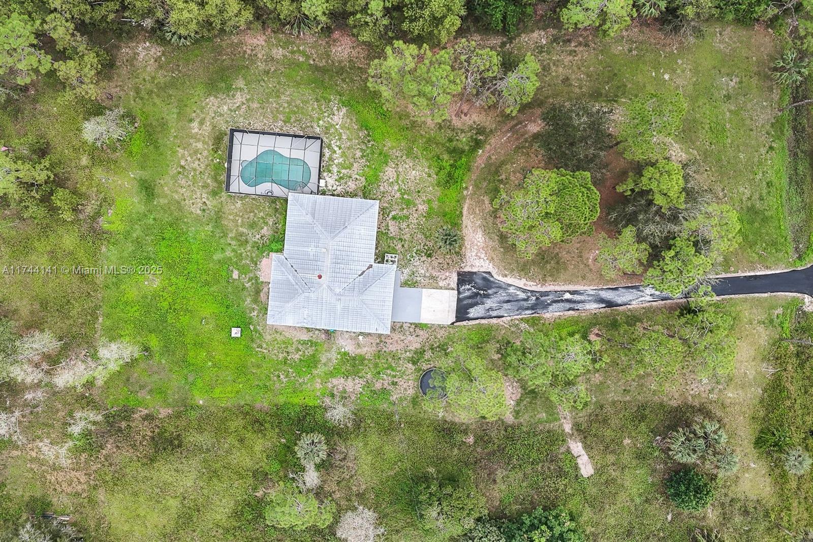 Stunning 4 Bedroom + Den, 3 Bathroom Home with Pool on 2.58 Acres, Plus Studio Suite. NEW ROOF (by county records), AC 2024, Water system 2023, Pool equipment 2024, Impact resistant windows 2024, and fully remodeled. Welcome to your dream home! This expansive 4 bedroom + den, 3 bathroom house is move-in ready. The home boasts a total of 3,523 sqft, including a recently remodeled garage studio/efficiency mother-in-law suite, fully permitted by the county, complete with its own bathroom and room—perfect for added flexibility or rental potential. Enjoy spacious living with fully remodeled bathrooms and ample space for family and guests. Relax in the large 14x32 pool fully screened, offering privacy and comfort.