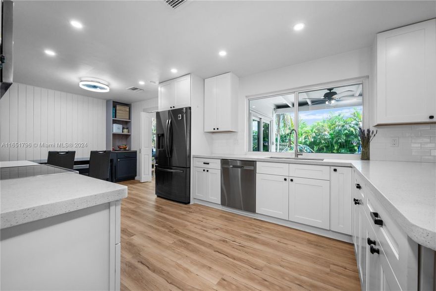 Beautifully renovated four-bedroom, two-bath home with office, set on a generous 11,483 sq. ft. corner lot with a spacious backyard. This home features a bright, airy living room with custom built-in cabinetry. The renovated kitchen is a standout, featuring custom cabinetry, quartz countertops, high-end appliances, and a breakfast nook. The property also has a small home office with its own private entrance, ideal for work or quiet time. Every detail has been thoughtfully updated, including impact windows/doors, modern bathrooms, luxury vinyl flooring, fresh paint, a new AC system, a tankless water heater, a large laundry/utility room, and an outdoor 220V outlet. Centrally located near highways, shops, dining, hospitals, and beaches, which adds additional convenience to day-to-day living.