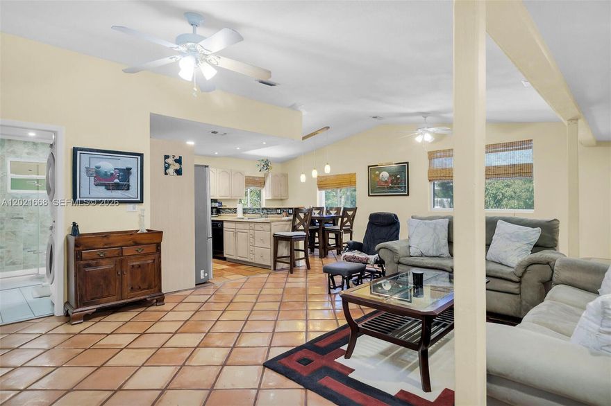 Nestled among mature tropical trees with only one neighboring property, this 3BR/2BA two-story home presents a peaceful, low-density setting just approx. 800 ft from a private homeowners’ park with beach, dock, and boat ramp for convenient access to Florida Bay. The home features an enclosed interior staircase connecting both levels, supporting its legal 3-bedroom configuration and providing a cohesive single-family layout.

The lower level is dedicated to the primary suite with ensuite bath and access to an enclosed, air-conditioned patio with large windows and a separate exterior entry—that can be used for a home office, studio, or flex space (non-bedroom). Upstairs, the open-concept living area is bright and functional, with terracotta tile throughout the main living spaces and a natural flow between living, dining, and kitchen areas. Two additional bedrooms with wood laminate flooring and a full bath complete the upper level.

Additional features include accordion hurricane shutters, ceiling fans, recessed lighting, two separate A/C systems, and two water heaters (2022 A/C and 2023 water heater upstairs). The property also has a one-car garage/workshop, exterior-access storage, and ample parking for multiple vehicles, a boat, or RV. Surrounded by established tropical landscaping, this property presents a unique combination of setting, layout, and proximity to water access.
