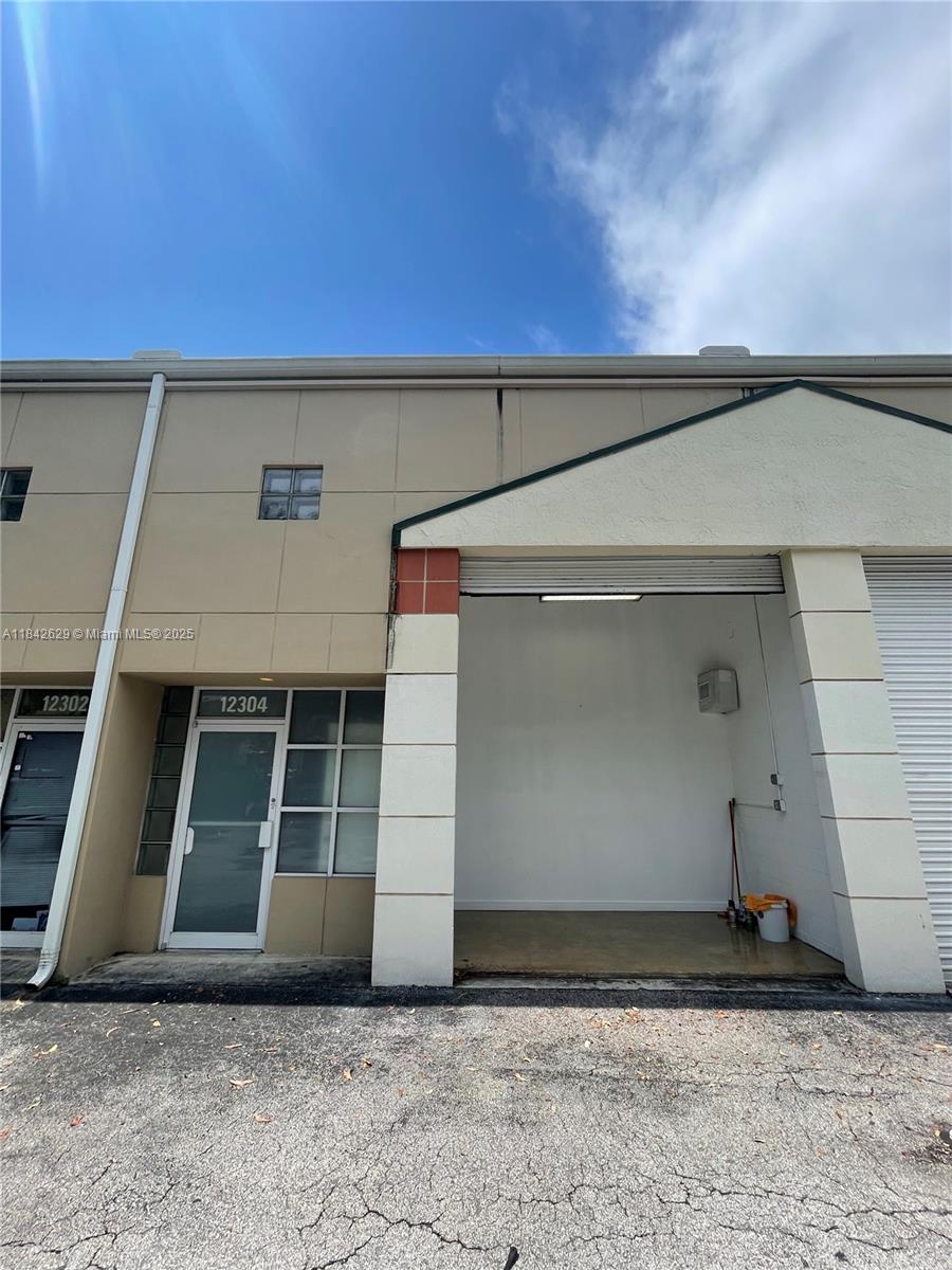 Impeccable mini warehouse, featuring a main floor plus mezzanine, a restroom, a utility sink, and a roll up door with polished concrete flooring. This versatile space is ideal for use as a showroom, an office with storage, or general warehouse and storage purposes