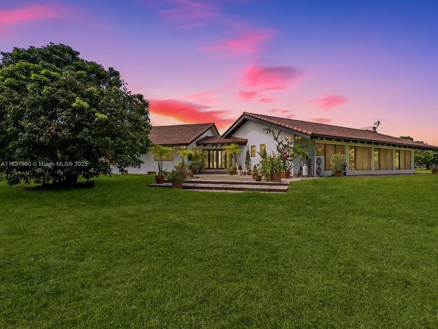 A rare 4.75-acre estate in the heart of the Redlands, just 20 miles SW of Downtown Miami. This income-producing tropical grove features over 300 mature lychee trees, plus mango and mamey. The main residence offers 4BD/2BA with soaring 18FT vaulted ceilings, exotic Western Red Norwegian wood throughout, and a fireplace wrapped in NC cherry stone. Impact glass and sliding doors bring in panoramic views of lush nature from every room. A detached 1BD/1BA guest cottage adds versatility for guests or passive income. Recent upgrades include a new Brava tile roof, two 50FT-deep wells, full irrigation system, and automated gated entry. Adjacent to a serene 44-acre preserve, ensuring total privacy. Seller financing available—perfect for those seeking beauty, tranquility, and opportunity.