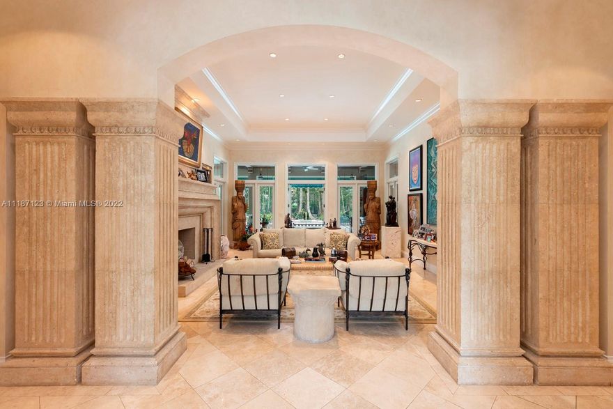 Resting on a gated 1.5-acre oasis in North Pinecrest, this celebrity-owned 6-bed, 5.5-bath estate designed by Ramon Pacheco is a highly private and lush retreat embraced by mature oaks, exotic palms, fruit trees, and two state-of-the-art koi ponds. The interior boasts vaulted ceilings and custom built-ins throughout, exquisite coquina stone columns, carved wood arches, and a split floor plan. Entertain or unwind in the glass-enclosed patio in the rear, featuring an all-wood beamed ceiling, coquina-carved faux fireplace, 180-gallon aquarium, and floor-to-ceiling windows that offer expansive views of the pool deck and lush garden, creating an awe-inspiring area where home and nature converge. Known as Casa Macao, this one-of-a-kind property is a union of top-quality design, art, and comfort.