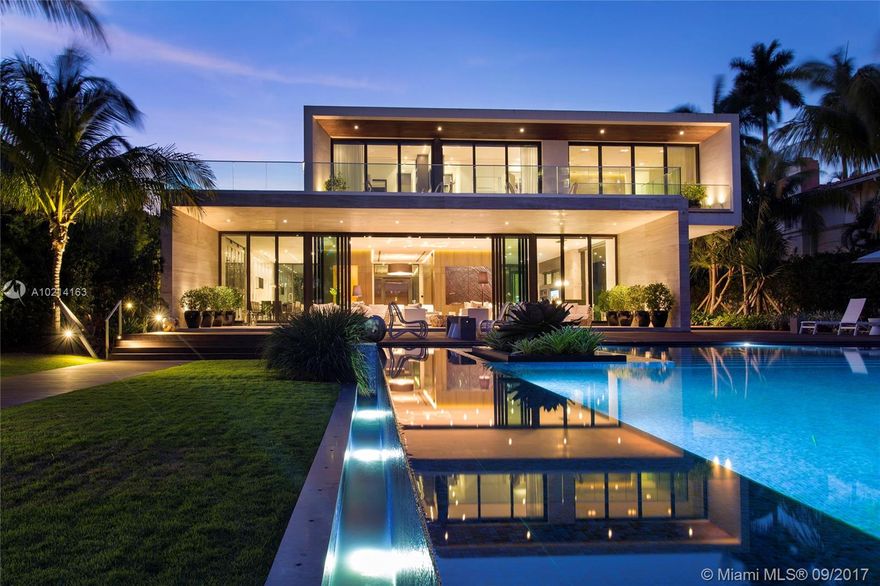 Prepare to be left speechless. The custom built 11,985 total SF fully automated smart home contemporary masterpiece offers luxury waterfront living at its finest. Indoors & outdoors blend together in perfect harmony to create an amenity rich residence that boasts 3 separate structures w/a VIP guest suite,health spa w/state-of-the-art fitness center, stunning 1,600SF pool surrounded by lush flora & fauna,60FT rectangular terrace covered by a magnificent stone overhang + an impressive gated stately entrance