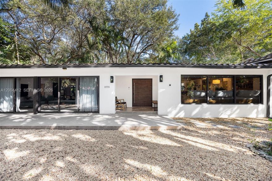 Discover the pinnacle of Tropical Modernism in this South Coconut Grove home, completely reimagined in 2024. Spanning 2,666 SF on a lush 10,500 SF corner lot, this turnkey 3BD/2.5BA residence offers a rare blend of high-end sophistication and the effortless soul of the Grove. The home's innovative design features a newly enclosed breezeway beneath vaulted ceilings, seamlessly uniting the living spaces. The primary suit is a secluded masterpiece, occupying its own private wing for ultimate tranquility. Every inch has been elevated, from the chef's kitchen with Calacatta marble counters and bespoke lighting to spa-caliber bathrooms and expansive windows showcasing the verdant surroundings. The grounds are a private sanctuary designed for the wellness-conscious entertainer. The backyard features a built-in BBQ, a soaring pavilion above a custom fire pit, and a jacuzzi/cold plunge circuit. Complete with a single car garage and secure gated entry, this home is minutes away from the Grove's elite schools and bayfront parks. This property offers significant long-term upside as a luxury asset. The move-in ready home and oversized lot provide the rare opportunity to live comfortably while planning future expansion or development. There is also ample room to add a pool within the current footprint. Experience a lifestyle defined by privacy, design, and Miami elegance.