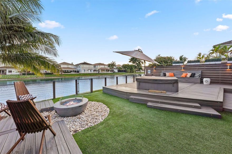 Enjoy gorgeous Miami sunsets lakeside in this beautifully maintained four-bedroom home within the gated community of Biarritz in Doral. Featuring a metal roof with a 55+ year warranty, this stunning lakefront residence offers a thoughtful layout with all bedrooms upstairs for added privacy. The backyard is an entertainer’s dream, showcasing an illuminated elevated deck with jacuzzi, outdoor shower, fire pit, zen garden, and extended covered dining area—perfect for gatherings or peaceful evenings by the water. This backyard oasis is the ideal tropical setting for outdoor grilling and entertaining. Additional highlights include a custom extended three-car paver driveway and low maintenance fee. $5,000 closing cost credit if close before March 31 2026.