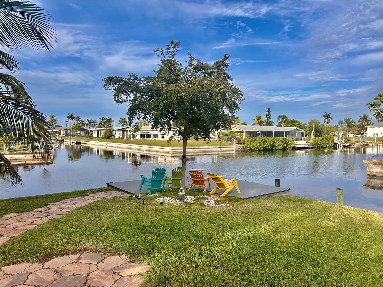 Beautiful waterfront home offering direct sailboat access to open water and the Gulf. Situated at the end of a cul-de-sac on an oversized intersecting canal lot, this property boasts 200 feet of seawall with riprap, a composite dock, and an 8,000 lb. boat lift. Inside, the open-concept layout showcases high-end finishes, a chef’s kitchen with an oversized island, and a spacious screened terrace—all with breathtaking water. The master and guest bedrooms feature French doors opening to the patio and canal. Additional upgrades include impact windows and doors, plantation shutters, new plumbing, metal roof, tankless gas water heater, new washer and dryer, remodeled garage, and more. Ample parking for RVs, trailers & multiple vehicles. No water intrusion from Hurricane Ian or Milton.