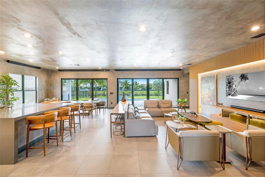 This two-story New York style contemporary home effortlessly blends modern luxury with artistic flair in the highly sought-after Lotus community in Boca Raton(Sumatra Model). Its exterior is a harmonious fusion of clean lines and dark finishes, creating a striking contrast against the vibrant cityscape. The living areas boasts floor-to-ceiling windows that flood the space with natural light, creating an inviting atmosphere grounding the space in warmth and elegance. The dark clean finishes of the walls provide an ideal backdrop for showcasing an eclectic mix of bohemian-inspired furnishings and contemporary art pieces. This home includes a wine cellar that is a sumptuous sanctuary for wine enthusiasts, and a movie theater right at home for a luxurious retreat for cinephiles.