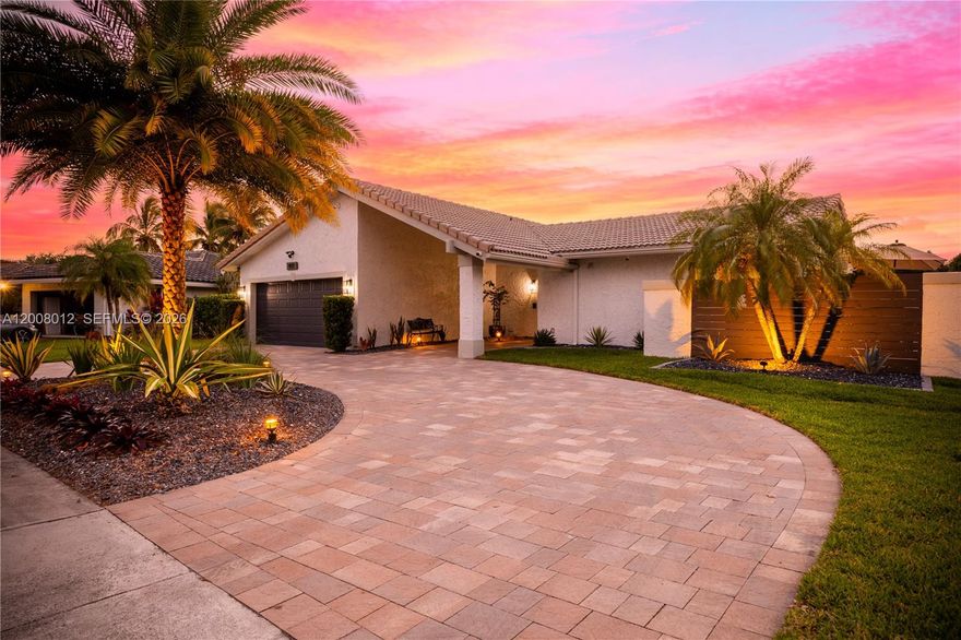 Beautifully remodeled home in the highly desired Jacaranda community. This is one of the only waterfront 4/2 properties in Jacaranda that has a large circular driveway, a lit poly deck, and a pool.  The interior has been tastefully remodeled while maintaining all of the home's unique original features such as 15+ft. vaulted wood ceilings and natural stone wood burning fireplace. You will enjoy a modern, open, and fully remodeled kitchen with under cabinet lighting, quartz countertops, large island w/quartz waterfall, & drawer microwave.  The AC was replaced in 2022 and the new unit includes a UV sterilizer.  All new AC ducts installed in 2025.  There are custom closets in every room and a tankless water heater.  The home has full impact windows and doors, including the garage door.  The air-conditioned garage has a polyaspartic flooring and built in custom cabinetry for extra storage.  The garage includes hidden stairs to the attic space which has lighting and a large area with a walkable surface and built in shelving for additional storage.  The home has 7 security cameras throughout that can be monitored from your TV or phone as well as a built-in surround sound system with speakers in the living room, dining room, and pool area.  The pool includes a solar heater and safety barrier.  The side yard has an additional gate which is great for pets so your fur babies can have their own play area or doggy run.  This home offers everything you could ask for and will not last long!