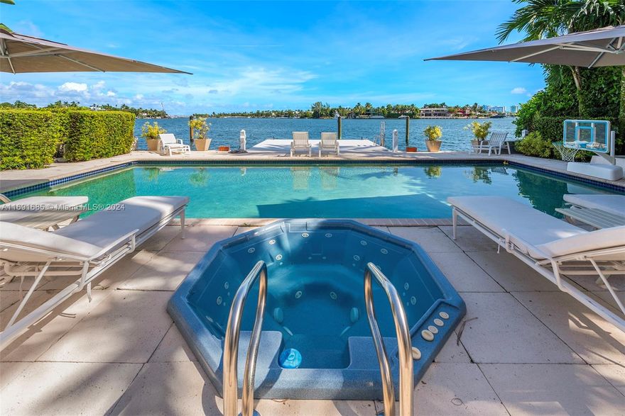 Imagine waking up to expansive bay views from your double-height living room in the exclusive, gated community of Hibiscus Island. This sprawling 6,124-square-foot, 5-bedroom residence offers a seamless blend of luxury and leisure, from sunny poolside mornings to festive evenings by the summer kitchen—ideal for entertaining. Visualize a private fireworks display over the bay or a sunset sail from your 70-foot yacht dock. Marble floors add sophistication, while the new gourmet kitchen features high-end Poggenpohl cabinetry and Miele appliances. With a media room, adjoining gym, and 6-car circular driveway, plus 60-foot Royal Palms and 14-foot privacy hedges, this island retreat offers endless possibilities to call your own.