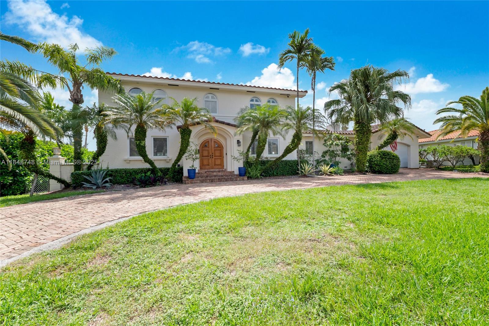 Pristine waterfront home for lease in the gated community of Gables by the Sea, offering 110' of water frontage with no bridges to the Biscayne Bay. This beautifully remodeled two-story residence features hardwood floors throughout, a stunning glass-enclosed, temperature-controlled wine cellar for 1,000+ bottles, a social bar-made for entertaining, and a spacious family room with fireplace that opens to expansive covered terrace. Enjoy outdoor living with a full summer kitchen, gas and wood BBQ, mini-fridge, ice maker, and a serene pool overlooking the canal. Upstairs includes the primary suite and two additional bedrooms; full cabana bath & en-suite guest room is on the 1st floor. Complete with boat davit, weather-station, circular brick driveway, & a whole-house generator. 2-car garage.