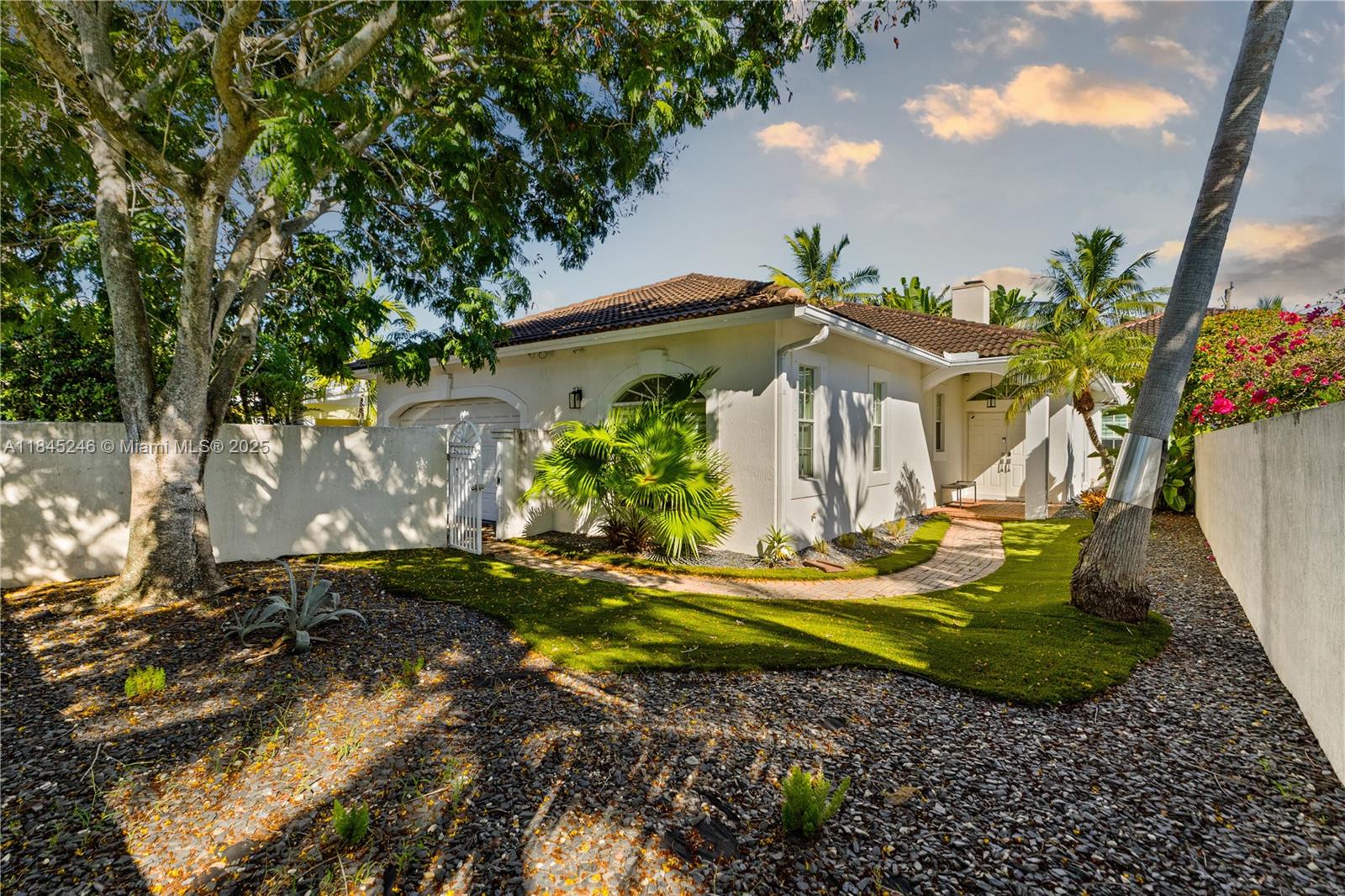 Welcome to a stunning 3-bedroom, 2.5-bath retreat that blends style and comfort in every corner. Step inside to soaring volume ceilings, a cozy decorative fireplace, and elegant marble and ceramic floors. The spacious chef's kitchen features a cooking island and pantry, flowing into a sunlit family room. French doors open to a tropical backyard oasis with a heated freeform pool and lush garden views. The luxurious primary suite boasts a Roman tub, dual sinks, and walk-in closets. Complete with hurricane shutters, a two-car garage, and impeccable finishes, this home is a true gem.