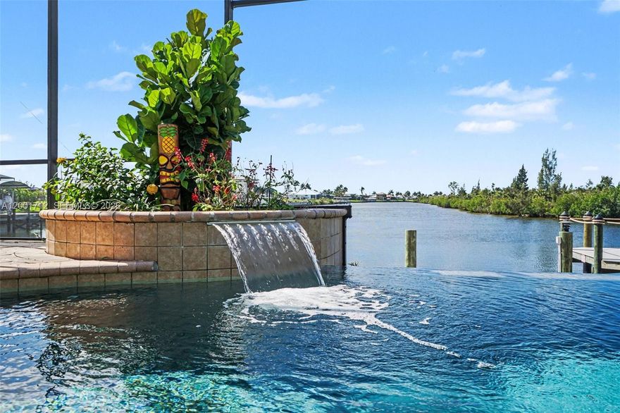 Experience the pinnacle of Southwest Florida waterfront living at 4214 Gulfstream Parkway in Cape Coral. From the moment you enter through the striking double etched French doors, you are immediately captivated by a breathtaking, uninterrupted view that flows through the home, across the stunning infinity-edge pool, and into one of Cape Coral’s largest and widest canals—truly one of the area’s most remarkable waterfront settings.
This exceptional concrete block residence offers 2,551 square feet under air and has been meticulously updated and maintained. A 2023 concrete tile roof, installed at a cost exceeding $100,000, while a newer central HVAC system installed in 2024 ensures modern comfort. The home has also been freshly repainted inside and out, presenting a crisp, move-in-ready appeal.
Designed with both elegance and functionality in mind, the home features a desirable split floor plan with 3 bedrooms and 3 baths. The expansive great room showcases vaulted ceilings with recessed lighting, a gas fireplace, and custom library-style built-ins flanking an impressive wall-mounted television. Pocketing sliding glass doors open fully to blend indoor and outdoor living, maximizing the spectacular water views.
Throughout the home, you’ll find refined finishes including plantation shutters, decorative niches adorned with hand-painted Florida murals, and thoughtful architectural details that add warmth and character.
The spacious kitchen is a true centerpiece, offering custom cabinetry, upgraded appliances, an eat-in bar, and a bright breakfast nook overlooking the water—perfect for casual dining with a view.
Step outside to your private resort oasis where the 60-foot heated infinity pool with saltwater and spa appear to melt seamlessly into the expansive canal beyond. The property is professionally landscaped with a full-yard irrigation system, creating a lush and inviting setting. 
Boating enthusiasts will appreciate the sea walled frontage, newly re-decked dock, and boat lift—ready for immediate access to Cape Coral’s renowned waterways.
Additional features include an oversized 3-car garage with abundant storage and a finished epoxy floor, along with a wide paver driveway and walkway that comfortably accommodates multiple vehicles. Also, A retaining wall was built behind the lanai. 
The primary suite offers a private retreat with multiple closets featuring California-style built-ins, providing both luxury and organization. The primary bathroom has his and hers sinks, and a walk-through shower. 
This is a rare opportunity to own a truly distinctive waterfront home where every detail has been carefully curated and every view is unforgettable.