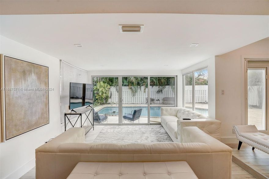 This newly renovated 3-bedroom, 3-bathroom oasis combines modern luxury with organic design in an open layout, perfect for refined living. At the heart of the home is a gourmet kitchen featuring a striking Quartzite island, stainless steel appliances, and a wine cooler, all overlooking the pool upon entry. Modern luxury vinyl flooring flows throughout, adding sophistication to every room. High-end finishes and furnishings elevate the home’s aesthetic, balancing elegance with comfort. Beyond the entertainment spaces, the property includes a converted garage as a third bedroom with personalized climate control. The open floor plan and spacious backyard create the ideal setting for seamless indoor-outdoor living, all just a short bike ride from the beach!