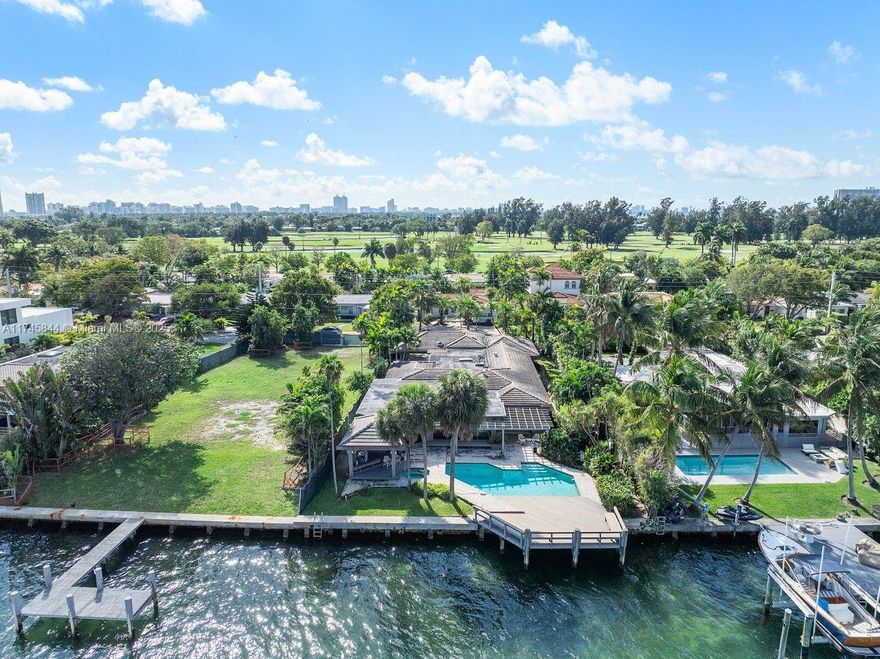 This exceptional waterfront Miami Beach residence on expansive Biscayne Bay epitomizes luxury living. Bring your boat, dock it, and unwind by the pool. Boasting four bedrooms and approximately 4,026 sq. ft., this spacious home is an ideal sanctuary for family life. The grand living area features a bar, pool table, and both a living room and Florida room, each with breathtaking water views. A two-car carport graces the front. Designed by renowned architect Barry Sugerman, this property is just 15 minutes from South Beach and Bal Harbour, nestled on a guarded island near Normandy Isle Golf Course.