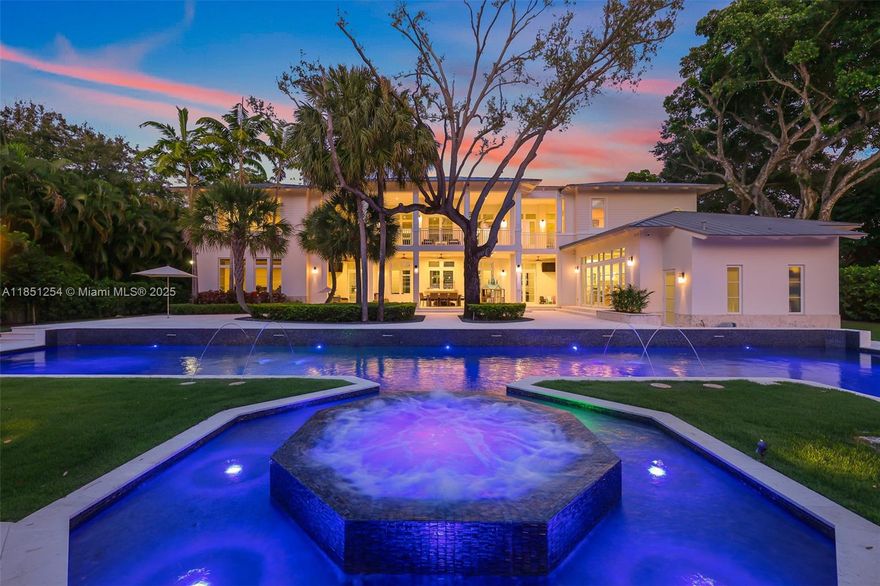 This breathtaking custom two-story estate sits on over an acre of beautifully landscaped grounds in the prestigious Village of Pinecrest. Spanning over 13,000 total square feet, it offers 8 spacious bedrooms and 10.5 luxurious bathrooms. Inside, you'll find wood accents, soaring vaulted ceilings, and a temperature-controlled wine cellar. The gourmet kitchen showcases top-tier appliances, while a smart home system enhances everyday convenience. The resort-style backyard is designed for both relaxation and entertaining, featuring an Olympic-sized lap pool with underwater speakers, a summer kitchen, basketball court, and private guesthouse with a full kitchen and bath. Just minutes from top-rated schools and scenic parks, this exceptional estate embodies refined South Florida living.