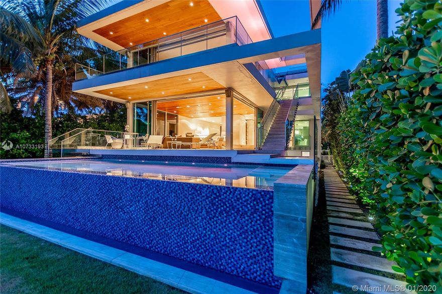 Bayfront. Spectacular. Exclusive. This Reinaldo Borges-designed trophy home on Miami Beach's exclusive Palm Island is a model of South Florida's world-famous tropical luxury lifestyle. Sunshine pours in everywhere through wrap-around glass walls & floor-to-ceiling windows. The infinity pool and 1,600 SF rooftop terrace overlook the water and cruise harbor, broadening the residence's exotic resort ambiance. The fabulous custom floating wood staircase, 20-ft ceilings, enormous dual-island La Strada kitchen, 90-bottle wine cooler, and spa-like atriums number a few more highlights of the home's magazine-worthy design. The property is boat-ready, with a private dock & lift. Bonus features incl. a Florida room, staff or guest rooms, an elevator, and a 2-car garage. 6BD / 7.5BA / 6,139 SF