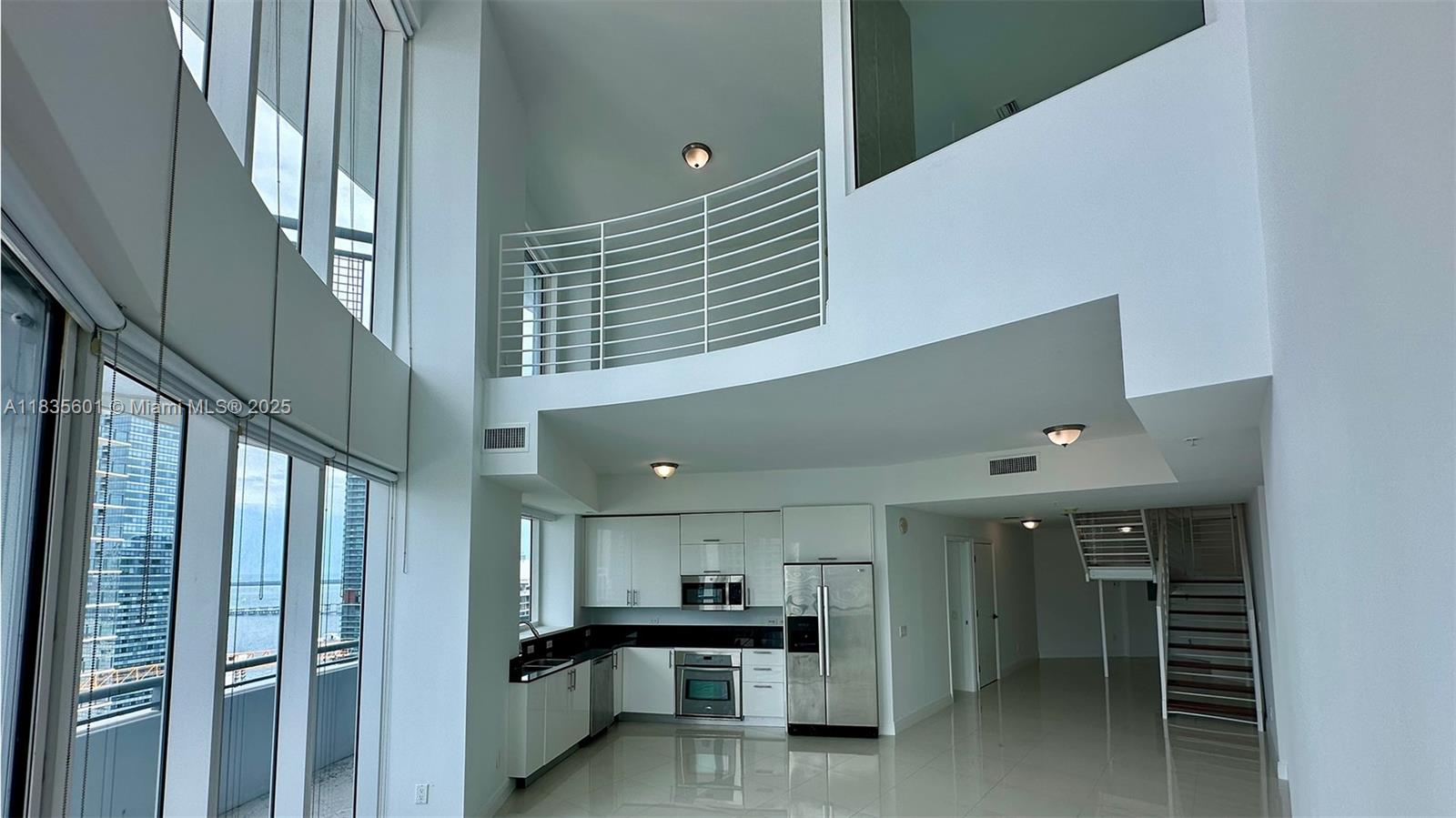 Spacious 3 Bedroom 3 Bathroom loft at The Infinity at Brickell with 1472 sq ft. Soaring double height ceilings and floor-to-ceiling glass windows fill the open layout with natural light and offer stunning bay and city views. The bright, air loft is perfect as a sleeping area or home office, featuring a full bath and closet. Enjoy two balconies that extend the living space outdoors. White, glossy, modern flooring enhances the large, elegant space throughout. Residents have access to resort-style amenities including an infinity pool, jacuzzi, gym, clubroom, valet, and 24-hour security. Available now, easy to show!