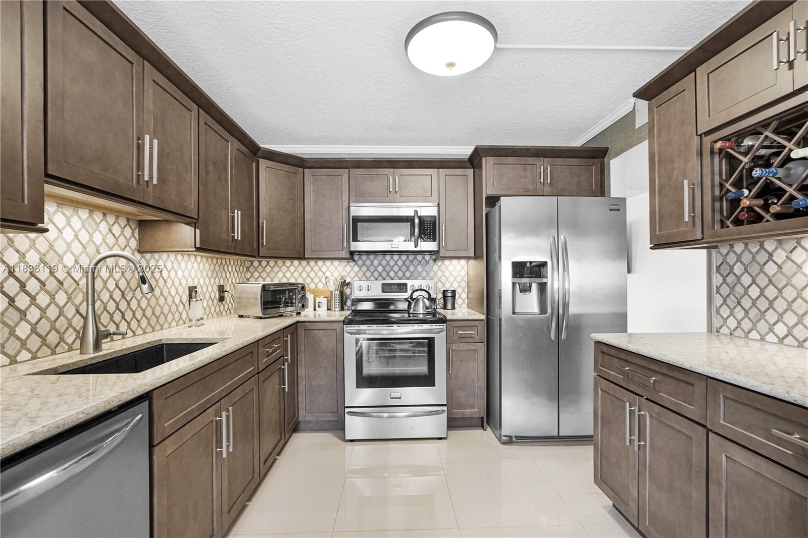 Step into one of the largest corner units on the first floor of the gated 55+ community of Century Village—it’s fully remodeled and absolutely gorgeous! You’ll love the open feel and the peaceful golf course views. Inside, the kitchen and bathrooms have been beautifully updated, and the entire unit features sleek, large-format porcelain tile floors. There's a washer and dryer in the unit, a newer tankless water heater, and the A/C was replaced just five years ago and still under warranty. The ceilings have a nice knockdown texture, there’s a roomy walk-in closet, and a cozy eat-in kitchen. Accordion shutters are also installed for extra protection.