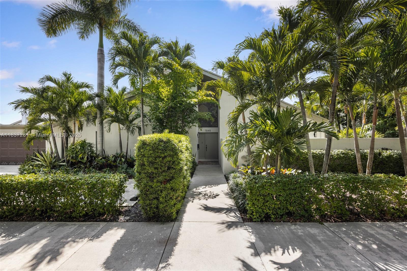 A fully renovated designer retreat in Banyans of South Miami, where modern comfort meets timeless style. This loft-style home features soaring 22-ft vaulted ceilings, expansive bedrooms with walk-in closets, and porcelain tile throughout. Two luxurious primary suites include spa-like baths with soaking tubs and dual sinks. The chef’s kitchen boasts a striking stone island, Bosch appliances, and opens to a lushly landscaped yard with a custom outdoor kitchen. Smart home features, impact windows, a 2-car garage with A/C and EV charger, plus access to a community pool and tennis courts complete the offering.