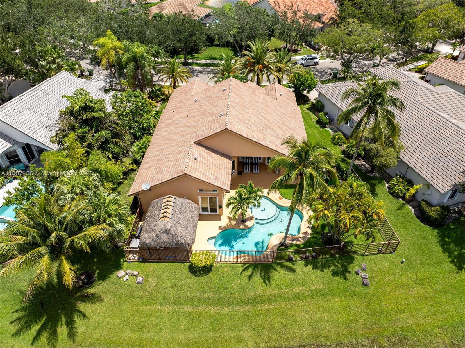 Discover this stunning home located in Weston Hills Country Club. Resort-style living features five bedrooms and three bathrooms, with the fifth bedroom equipped with a Murphy bed. ALL windows and doors are Hurricane impact-resistant. The high ceilings throughout the home allow for plenty of natural light. The open floor plan offers breathtaking water views from all the main living areas. Enjoy beautiful travertine floors and an updated kitchen complete with wood cabinetry and granite countertops. This magnificent waterfront residence boasts lush landscaping from front to back and features a resort-style lagoon pool with a heater and a private tiki hut, perfect for entertaining.