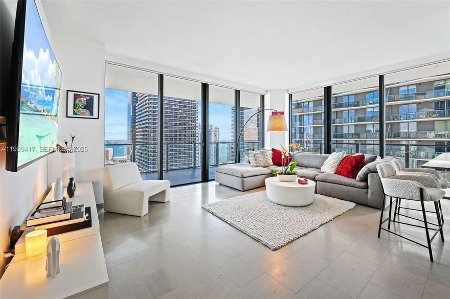 Experience luxury living at this stunning corner residence featuring 2 bedrooms and 2.5 bathrooms, offering sweeping panoramic views of the Miami skyline, Biscayne Bay, and the horizon toward Coconut Grove and the shoreline. This elegant home boasts floor-to-ceiling impact windows, bright open living spaces with marble floors, and a wraparound balcony. The modern kitchen is beautifully appointed with sleek Italian cabinetry, premium Bosch appliances. The primary suite with a spa-inspired bathroom with a rain shower and refined finishes, and a generously sized walk-in closet. The second bedroom is ensuite with equally impressive views, complemented by a guest bathroom for added convenience.  Enjoy resort-style amenities in all within one of Miami’s most sought-after neighborhoods.