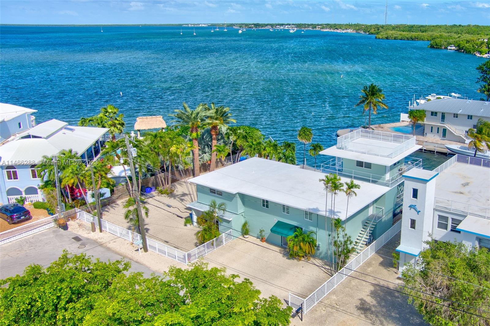 BREATHTAKING OPEN WATER VIEW! This is a wonderful opportunity to own a large solid concrete waterfront home on a double lot in Pirates Cove with incredible bay views offering desirable 100' of waterfront, a 75'concrete dock featuring 4 post cradle boat lift with 20,000lbs capacity and one Davit. Plenty of space in the 4 bedrooms/4 bathrooms offering several opportunities for family, friends, or in-laws to stay with private access and ensuite bathrooms. Large updated new kitchen with large island and top of the line appliances. The bonus room on the 3rd floor may be ideally used as an office, exercise room, or kids play/study room. Rooftop observation deck with phenomenal views of the bay and 360 views.