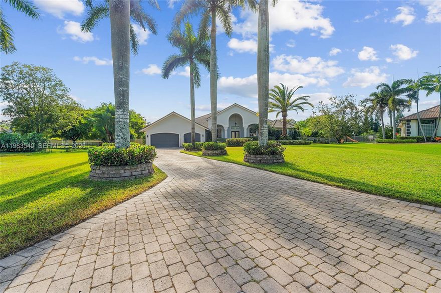 Set within the gated enclave of Emerald Springs Estates, this modern elegance is on the community’s largest lot with 1.5 acres of beautifully designed grounds, complete with a private sports court and resort-style outdoor living. Fully remodeled in 2021, the home offers 4 bedrooms and 4 bathrooms, each updated with new showers, designer fixtures, custom closets, and sleek white porcelain flooring that carries throughout the residence. The primary suite is a true retreat, with an oversized room highlighted by a Chanel-influenced walk-in closet with luxury designer flooring. The kitchen is equally impressive, reimagined with top-tier finishes and a complete collection of Fulgor Milano Italian appliances, including two refrigerators, a wine fridge, double oven, drawer microwave, built-in espresso machine, an island beverage fridge, and a Bosch dishwasher. Three A/C units, a new water heater, new washer and dryer, and accordion shutters offer comfort and peace of mind. The pool and spa were fully renovated in 2021. Expansive outdoor space and room to personalize with an outdoor kitchen or additional amenities, this rare Davie estate blends luxury, privacy, and scale in a way few homes can match.