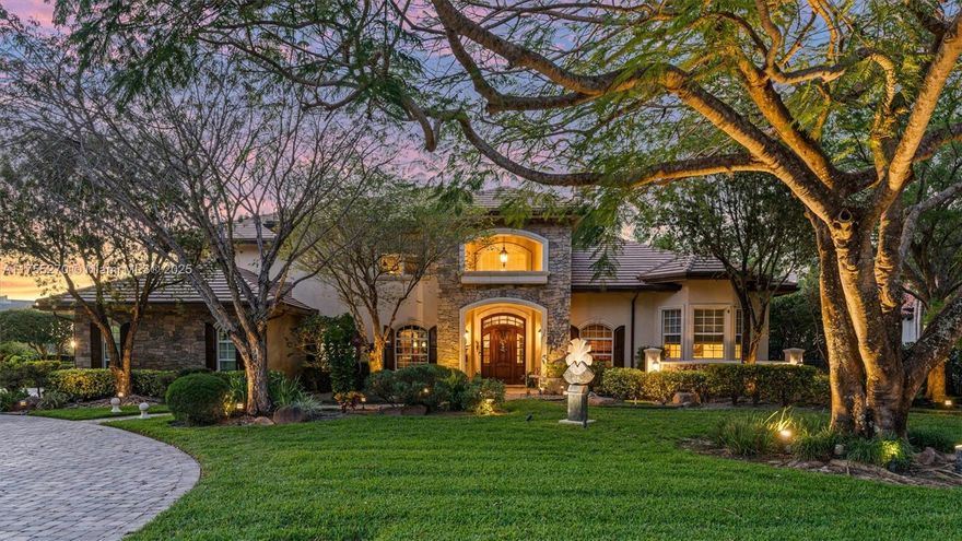 WELCOME TO EXCLUSIVE COMMUNITY OF GRAND OAKS IN DAVIE! This stunning lakefront estate is 1 of 32 custom homes. It offers 5 bedrooms, an office, loft, 5.5 baths and sits on a builder's acre. Enter through soaring 20’ ceilings in the foyer, living, and family rooms, both with fireplaces. Enjoy wood, marble, and Jerusalem stone finishes. A custom bistro bar, hand-painted murals, and Chicago brick accents enhance the kitchen and butler’s pantry, with a Thermador gas cooktop, grill, and pot filler. The in-law suite has a private entry, private kitchen and cabana bath. The lush, tropical yard boasts mature landscaping, a resort-style pool with a waterfall spa, a summer kitchen, all-impact glass, a 48KW generator with a 1,000-gal tank, and a 250-gal tank for the BBQ, cooktop, and fireplace.