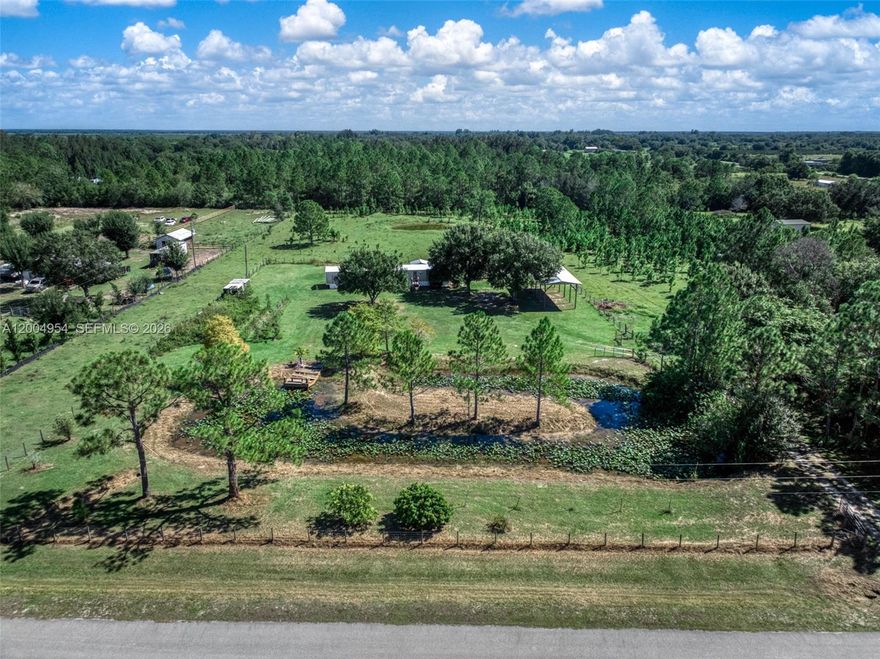 Nearly 5 acres in Lorida of true agriculture land-complete with a mobile home, an outbuilding that has been converted into a cabin like apartment, a tall pole barn, fencing, gated, pond, and some garden areas that just need a little TLC to spring them back to life. The mobile has a newer metal roof (2024) and the inside has a spacious living area/kitchen but it does need work. This property is super unique and is harder and harder to find these days. The property is about , about 20 minutes to Publix and also to Downtown Sebring, 3 hours away from the Miami airport, and under 2 hours to Disney World.