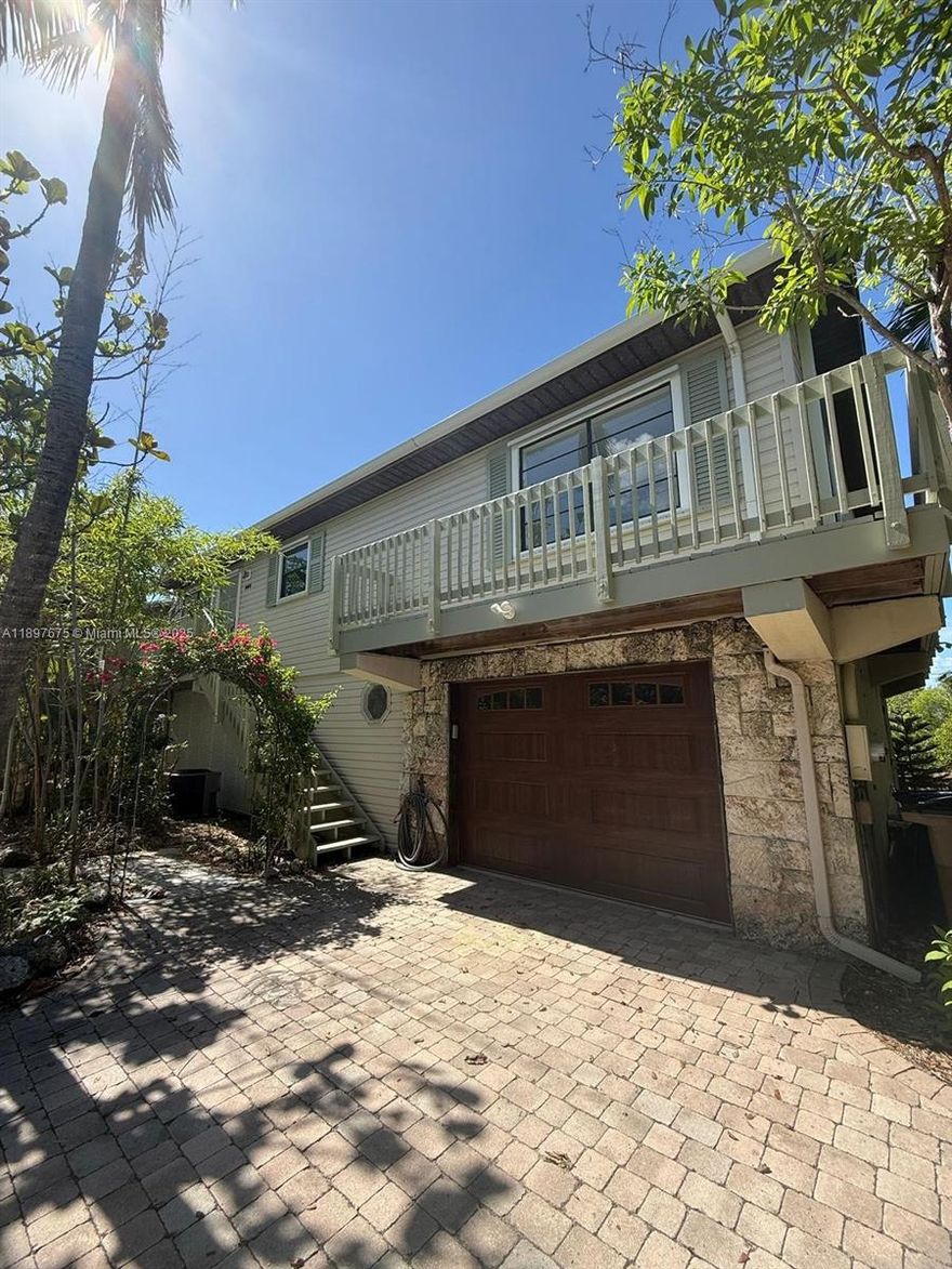 Beautiful canal-front stilt home for sale in Key Largo! This elevated single-family property offers 2 bedrooms, 2 bathrooms, and a bright open-concept living area and open kitchen with a large balcony to enjoy stunning water views and tropical breezes. The ground level includes a finished garage and storage area with plenty of space for tools or water toys. Perfect for boat lovers, the home sits on a private plugged canal. Built in 1985 and well maintained, featuring wood floors in the common areas and ceramic tile floors in the bathrooms, central air, and a spacious 4,500 sq ft lot with a paved driveway and lush landscaping. Ideal for vacation living or your Keys getaway — move-in ready and priced to sell!