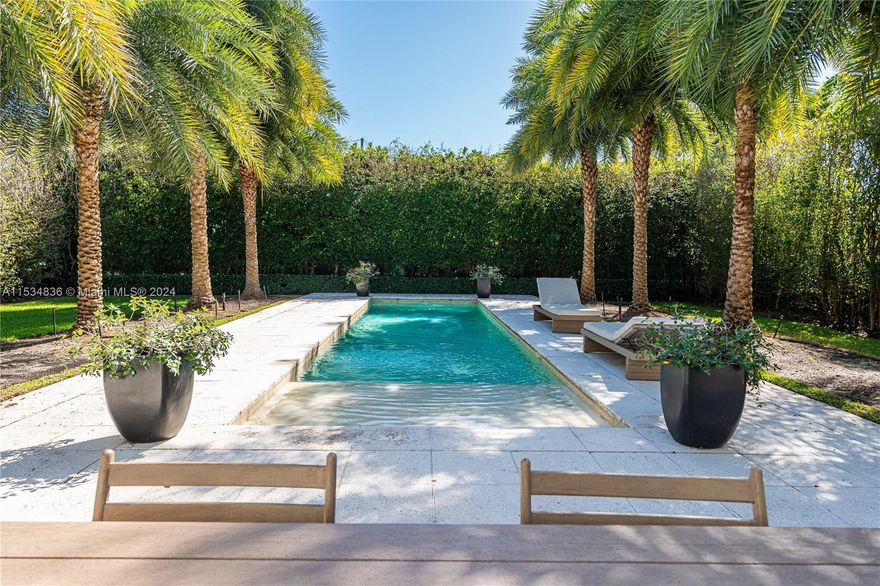 Welcome to 910 N Venetian Drive. This architectural gem, "Heller House 1"  was designed by famed architect Igor B. Polevitzky. Recently updated, this 2-bed, 2-bath home is a sanctuary of tranquility, featuring high ceilings, brick walls & 13' windows that fully open into a seamless indoor-outdoor space. The backyard, with a fully motorized, retractable awning, is the perfect place to entertain & host dinner parties, framed by rows of Royal Palms flanking a large 12x40 pool. The 9,000sqft oversized lot is a developer’s dream, affording plenty of room to add on or build your dream home with unobstructed bay views from your future second floor or rooftop terrace. Prime location in Miami's most coveted neighborhoods, this home offers the ultimate blend of luxury, privacy, and convenience.