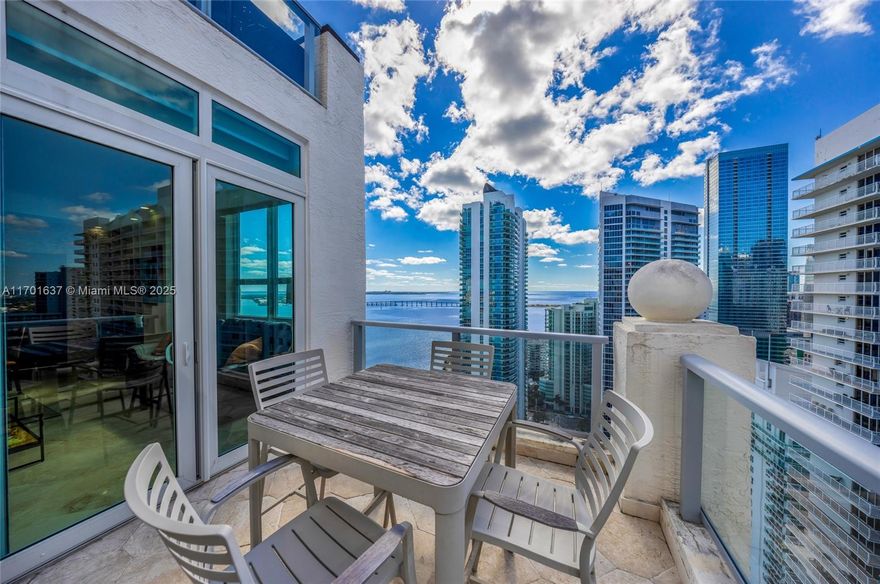 Immaculate corner penthouse with 2 master suites and 2.5 baths boasting expansive bay and city views. This unique unit has 10ft ceilings, polished marble and real wood floors together with a brand new kitchen, top of the line appliances and mahogany wood doors throughout with 2 walk in closets and tons of storage similar to a single family house. New sliding glass impact doors open to a square terrace that is very useable with both sunset views to the west and open bay views to the east and southeast. 3 parking spaces. Enjoy amenities from Tennis courts, BBQ Grills, Gym, Market, Business Center, Bay-front pool and jacuzzi. Head down to "Crazy About You" on the first floor for happy hour, lunch or dinner in one of Brickell's only waterfront restaurants. Assumable loan at 2.875%