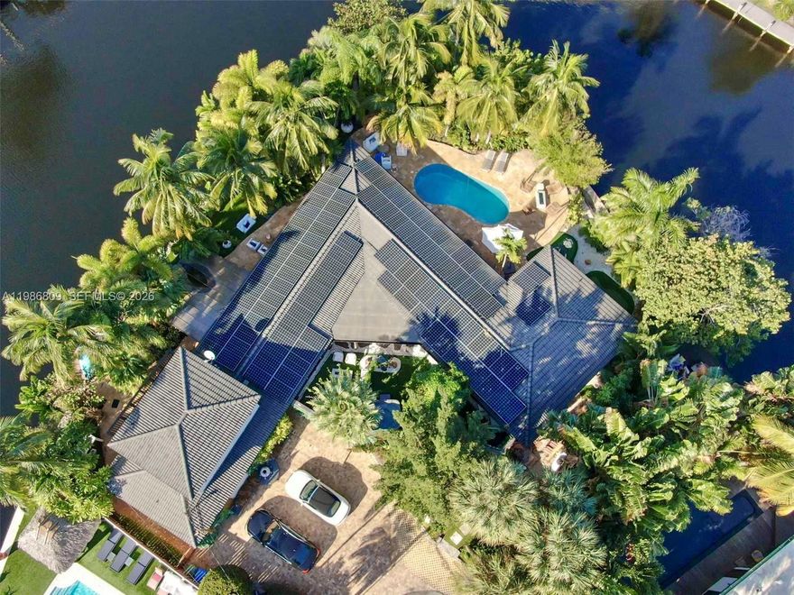 Welcome to “The Sanctuary,” a rare point-lot waterfront estate in Wilton Manors offering approximately 210 feet of ocean-access canal frontage with a 35 ft dock on a peaceful cul-de-sac. This 2-story, 5 bedroom, 4 bathroom pool home of about 3,611 sq ft on an oversize 0.26-acre lot is designed for luxury indoor–outdoor living, entertaining and boating. There is a true sense of magic here, with two magnificent, lush garden areas: an intimate courtyard patio with jacuzzi wrapped in flowering plants and trees, and an immense tropical backyard framing the heated pool, spa and wide waterfront views. Light-filled open spaces include a great room, family/game room, bar, custom built-ins, closet cabinetry, impact windows, and flexible bedroom layout ideal for guests, multigenerational living or home office. The gourmet-style kitchen connects to a large patio with summer kitchen, outdoor dining and lounge areas, plus putting green, fire features, fitness and meditation zones that make the property feel like a private resort. Green features such as solar panels, energy-efficient roof and windows, and air purification support a high-vibration, sustainable lifestyle with low utility costs. Located near Wilton Drive, beaches, shopping and dining in sought-after Middle River Estates, this unique waterfront villa is ideal as a primary residence, second home or high-end income property.