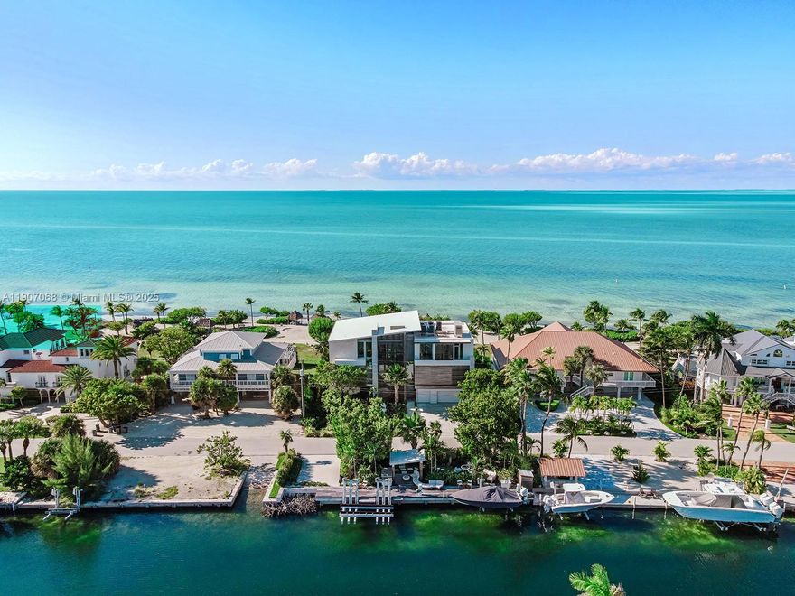 A rare architectural masterpiece by renowned architect Max Strang, this modern coastal estate in Port Antigua, Islamorada, redefines luxury waterfront living. Set on a private sandy beach, the residence offers 5 bedrooms, 6 full baths and 2 half baths across 6,367 SF of interior space and 10,483 total SF. Strang’s signature tropical modernist design showcases natural materials, clean lines, and expansive glass walls framing panoramic ocean views. Amenities include a gym, golf simulator room, movie theater living area and a spectacular summer kitchen for entertaining. Outdoor living shines with a resort-style pool, spacious terraces and direct beach access. Every detail embodies refined elegance, relaxed sophistication and the timeless allure of Islamorada’s coastal beauty. Fully furnished.