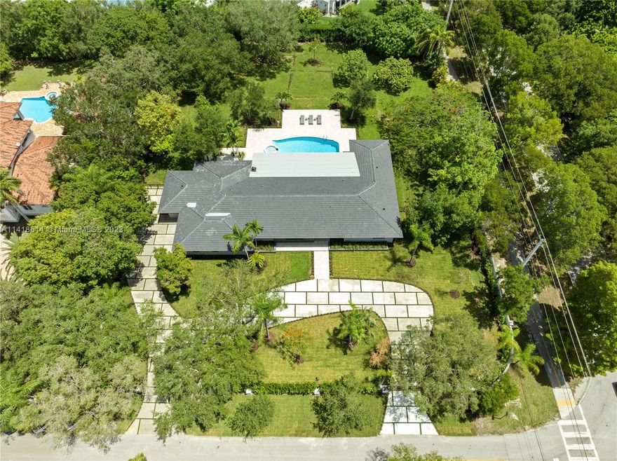 Pinecrest Acre+ Corner Estate | Fully Rebuilt 2023. A symphony of space, light & green views transforms this home into a retreat w/every detail a flawless achievement of custom-design, expertly crafted. A turf+cement driveway winds thru the gate & botanical garden to an automated pivot front dr w/fingerprint option. A vast open plan is unified by porcelain flrs & illuminated by recessed lights+natural light pouring thru banks of glass drs & picture windows, displaying the pool, covered lounge w/fabulous alfresco kitchen feat. black slab/wood accent counters, and lush sprawling garden. Wide-plank white oak flrs warm the bdrms’ ambiance. Quartz island & counters adorn the chef’s kitchen. Master suite incl. bonus rm. 2CG enhanced w/finished flrs+adj a/c bonus rm. 3 blks to Pinecrest Gardens.