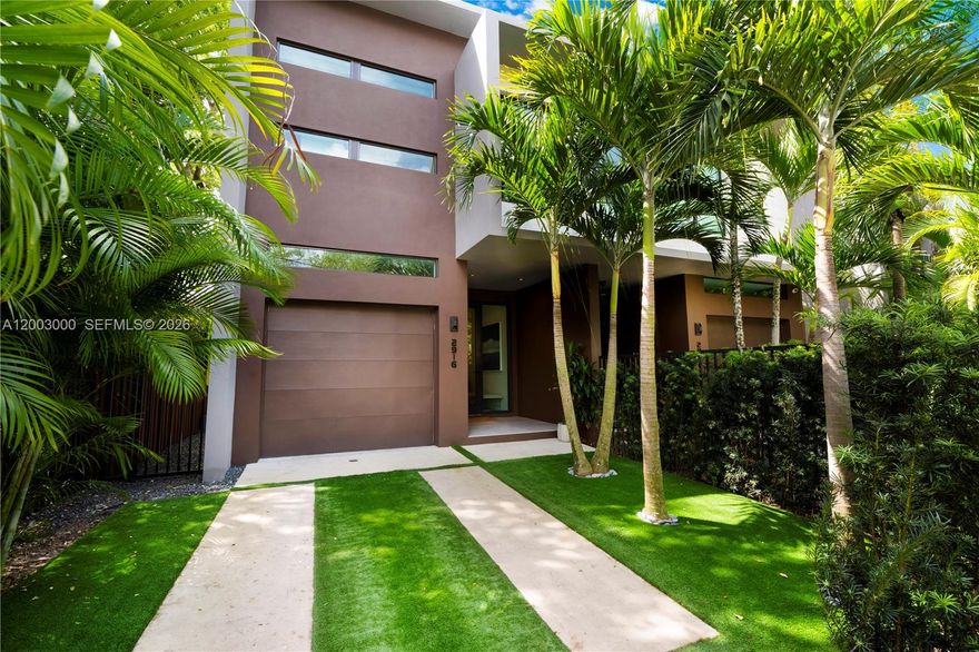 Discover modern luxury living in the heart of Coconut Grove. This thoughtfully designed home boasts an open, light-filled layout with high-end finishes throughout, creating an elegant yet inviting atmosphere perfect for everyday living and entertaining.
The expansive main level features a spacious dining area or secondary sitting space, complemented by large windows and doors that flood the interior with natural light while ensuring peace and security. The show-stopping kitchen includes custom Italian cabinetry, a large waterfall island, and an attached custom table, crowned by a dramatic modern architectural light fixture. Premium appliances along with European plumbing fixtures, complete this chef-inspired space. Large-format porcelain flooring flows seamlessly throughout the main level, with wood tile upstairs.
The family room impresses with a built-in Artefacto TV cabinet featuring custom wood slats and wallpaper accents, framed by custom linen curtains and motorized blinds for ultimate comfort and privacy. A dramatic modern glass stairwell adds architectural flair and connects the levels effortlessly.
Upstairs, the large primary suite offers a luxurious en-suite bathroom with a double shower and custom closets. Two additional spacious bedrooms share a Jack-and-Jill bathroom, while the generous fourth bedroom includes its own en-suite and walk-in closet.