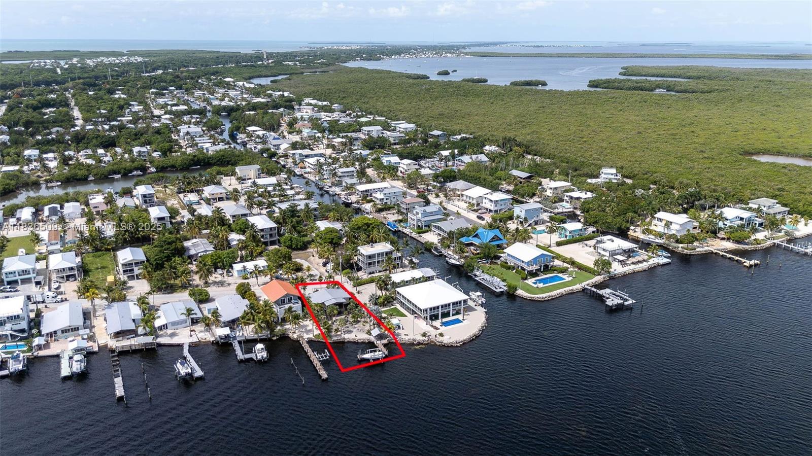 Fantastic bayfront property in the Bermuda Shores subdivision of Key Largo. This spectacular lot is ready to be your new vacation spot or the ideal fish camp! Sheffield steel beam construction style home with metal roof. Upstairs living space complete with impact windows and doors, open living room with beautiful wood ceilings, kitchen with breakfast area, and sliding glass doors out to a perfect screened porch where you can sit and enjoy the beautiful water views. 2 bedrooms and a full bath with shower. Wall unit ACs. Downstairs you will find tons of space for storage, a bedroom with closet and full bath. Laundry room. Spacious backyard with covered gazebo area, outdoor shower and seating. T-dock, 15,000lb boat lift, all ready for your entertainment and water activities!