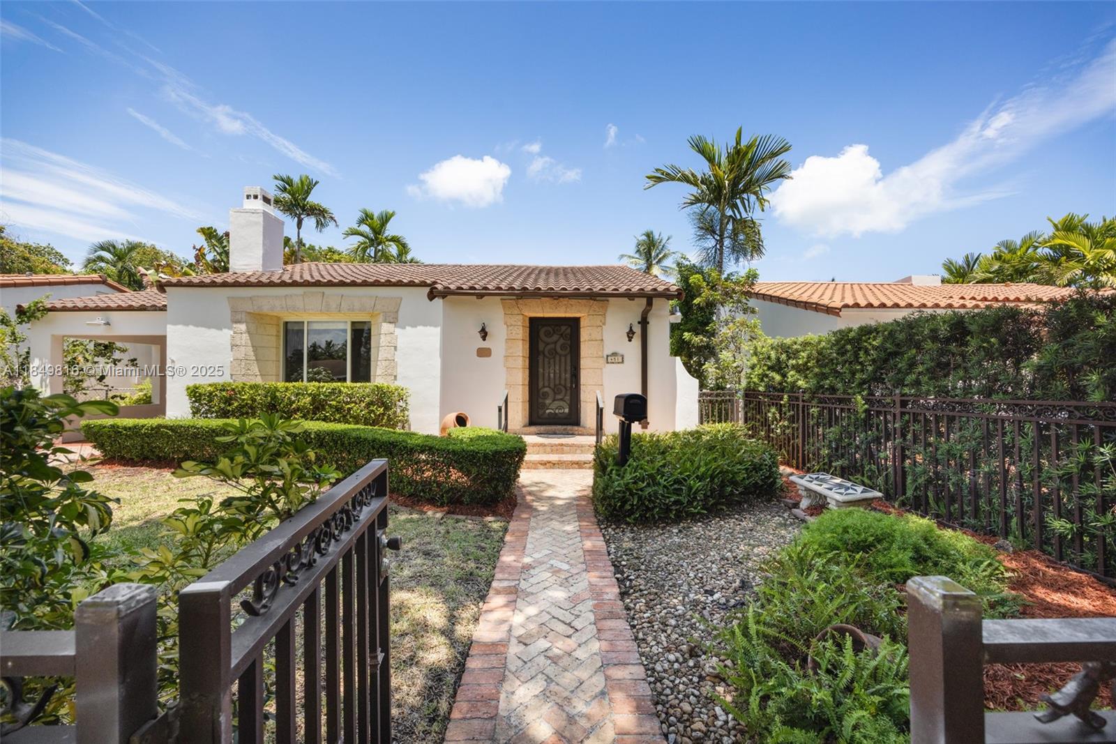 Charming home in The Roads with unbeatable curb appeal and fully gated. Enter through a terracotta-tiled foyer into an inviting living room with a limestone fireplace, built-in shelving, and exposed wood-beam ceilings. Hardwood floors flow into the dining room and bedrooms, each with cedar-lined closets. Enjoy an updated bath, granite kitchen with pantry, and a bright, light-filled family room with plantation shutters. Outside, a detached garage with full bath is ideal for a future guest house or in-law suite. Lush landscaping, an attached carport, and a spacious patio make entertaining easy—with room to add a pool. All this on one of The Roads’ most desirable tree-lined streets, just minutes from Brickell, Coconut Grove, and Coral Gables.