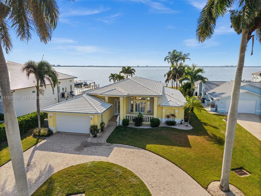 SOUTHERN EXPOSURE RIVERFRONT HOME ON AN OVERSIZED LOT WITH A MULTIMILLION DOLLAR VIEW! This DIRECT RIVERFRONT property is near Cape Coral’s Yacht Club area. SOUTHERN EXPOSURE on an oversized lot with 88 feet of Caloosahatchee River frontage and approx 200 feet of depth, with wide, unobstructed water views and direct sailboat Gulf access with no bridges. NEW SEAWALL installed after Hurricane Ian. Boaters will appreciate the two docks and boat lift. The home features 3 BR,  2 BA, and over 2,200 square feet of living space with 12+ foot ceilings in the main living area. Tile flooring and crown molding run throughout. Open kitchen with granite countertops and walk-in pantry. Two sets of pocketing sliding glass doors with full-length transom windows flood the home with natural light. The primary suite is generously sized with sliding doors to the pool area, two walk-in closets, and a large en-suite bath with dual vanities, a jetted tub, and a separate shower. Outdoors features a heated pool and spa surrounded by a beautiful travertine patio, all overlooking the river. The home does not have a pool cage, allowing for unobstructed views, but is equipped with electric roll-down screens at the rear and accordion shutters for storm protection. Offered fully FURNISHED AND TURNKEY, the property is currently part of a successful vacation rental program. This is a prime opportunity to own one of the most sought-after riverfront locations in Cape Coral.