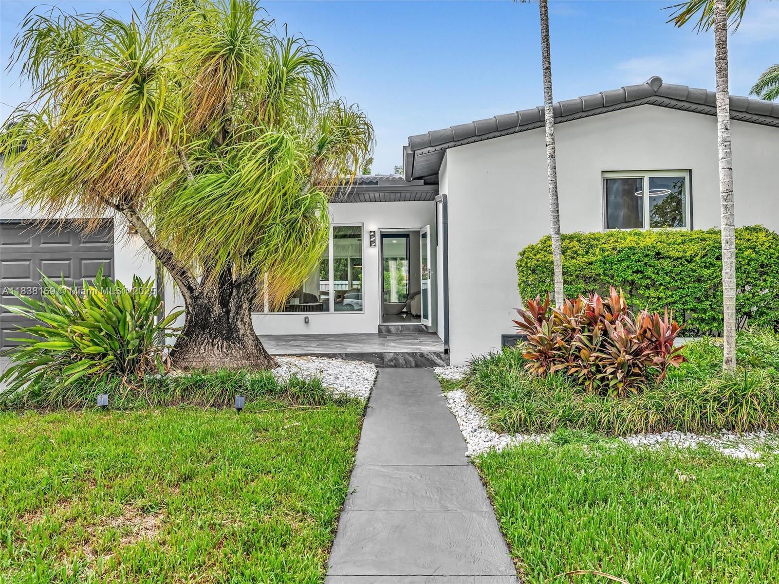 Fully renovated in 2025, this 3BR/2BA East Hollywood gem features modern design, impact windows & doors, custom glass partitions, and floor-to-ceiling glass overlooking a fenced backyard. Plumbing and electric are completely new, done with permits. Kitchen with engineered stone countertops, gas range, and stainless steel appliances. Bathrooms feature spa-style premium quality walk-in showers and LED mirrors. All bedrooms with natural wood flooring. Premium glass wine cabinet included. High-tech design in white, graphite, and natural wood. Tiled front courtyard, 1-car garage, extended driveway. Just 1.5 miles to Hollywood Beach & Broadwalk, and minutes to Downtown Hollywood, golf, parks, and shops. Roof 2006, excellent condition, no leaks.