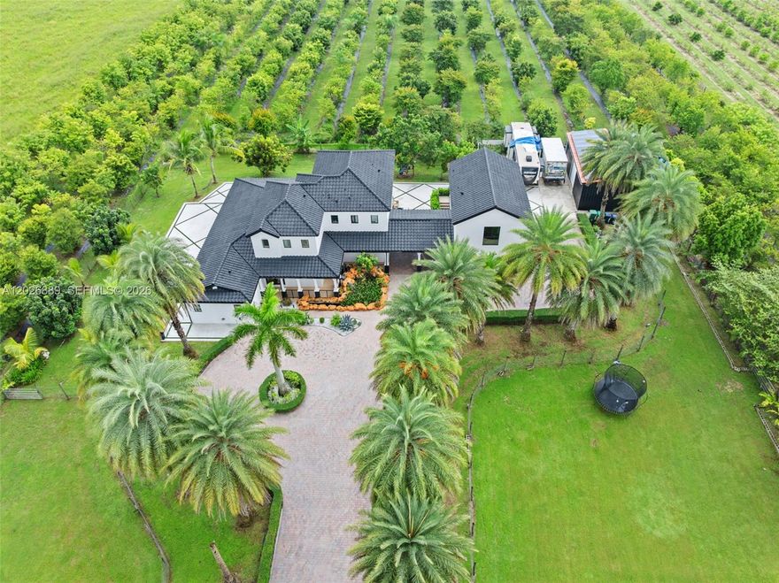 Rare opportunity to own a unique 4.6-acre modern estate in Homestead offering privacy, income-producing agricultural potential, and endless possibilities for country living. Motivated seller and ready for immediate occupancy. Built in 2007, this beautifully maintained turnkey furnished home features spacious interiors, soaring ceilings, abundant natural light, and modern/contemporary design throughout. Owner states actual living area is larger than reflected on tax roll. The property is a true tropical paradise with approximately 623 mature fruit trees producing year-round, including soursop, mango, coconut, jackfruit, sugar apple, star fruit, dragon fruit, sapodilla, papaya, guava, and more. Expansive grounds offer incredible flexibility for horses, animals, agriculture, nursery use, family compound potential, RVs, boats, additional structures, or recreational use. Circular driveway, covered parking, and ample additional parking space. Surrounded by lush greenery providing exceptional tranquility and privacy while still being conveniently located minutes from major highways, shopping, dining, and schools. A truly special South Florida property combining modern living with land, nature, and long-term potential.